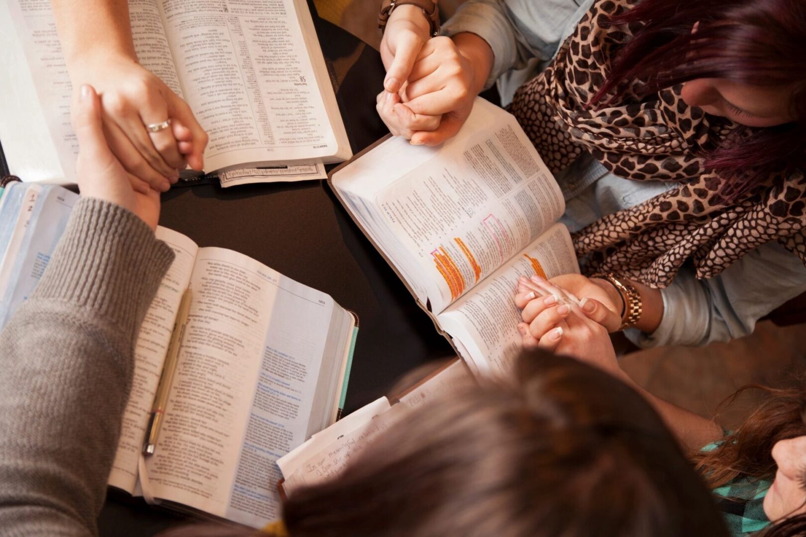 A group of people sitting around each other reading.