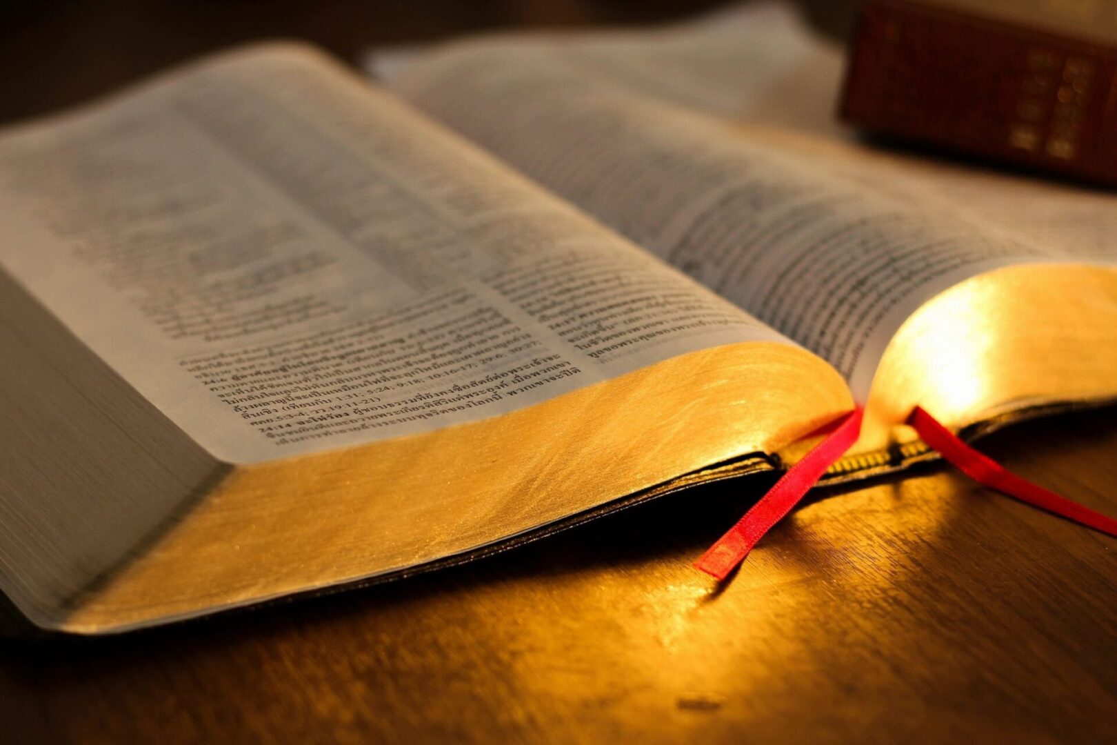 A lit candle is on top of an open bible.